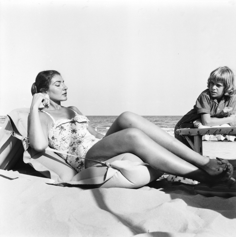 Maria Callas in a swimsuit on the beach.
