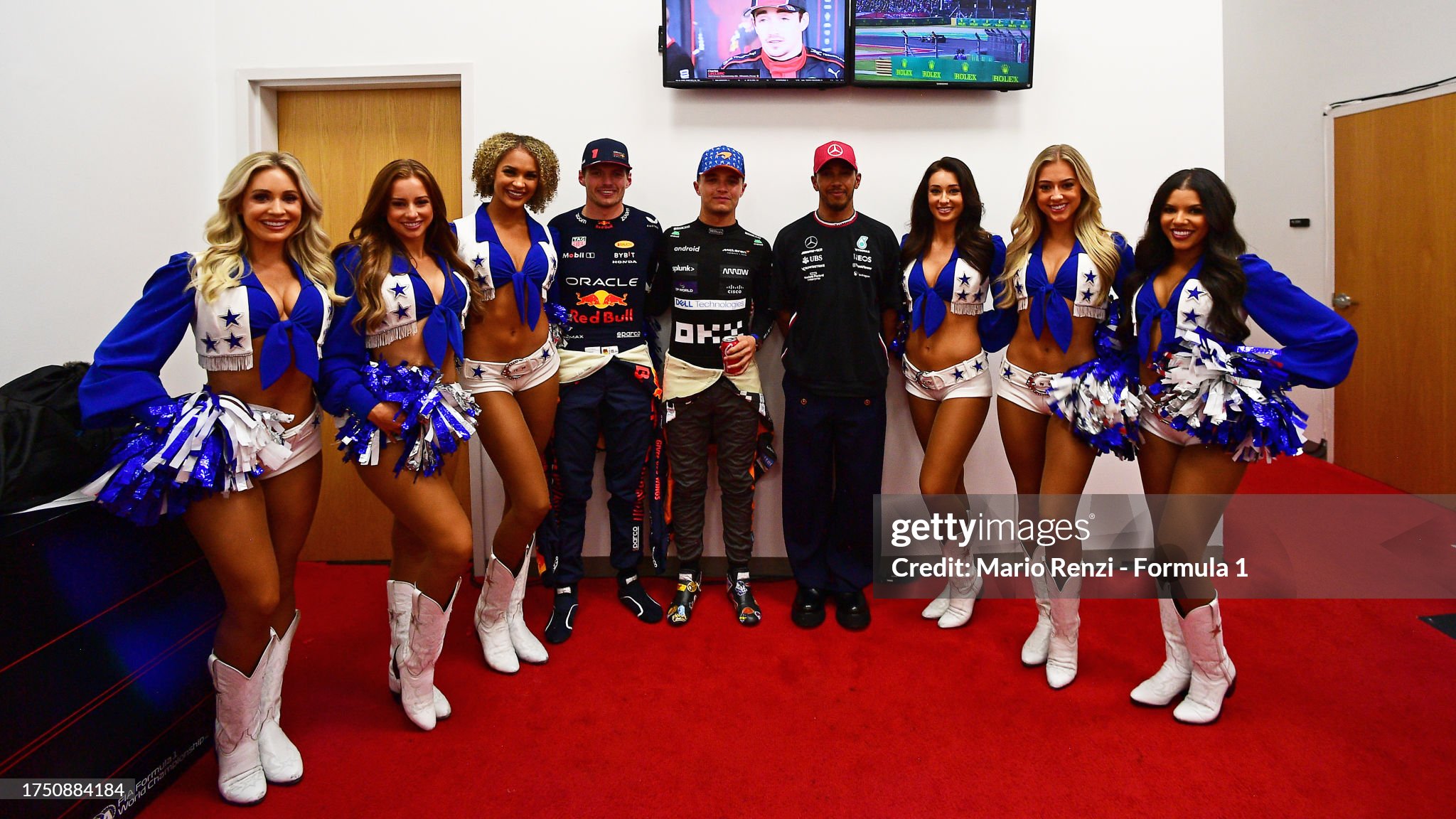 Race winner Max Verstappen, second placed Lewis Hamilton and third placed Lando Norris pose for a photo with cheerleaders at the F1 Grand Prix of United States at Circuit of The Americas on 22 October 2023 in Austin, Texas. 