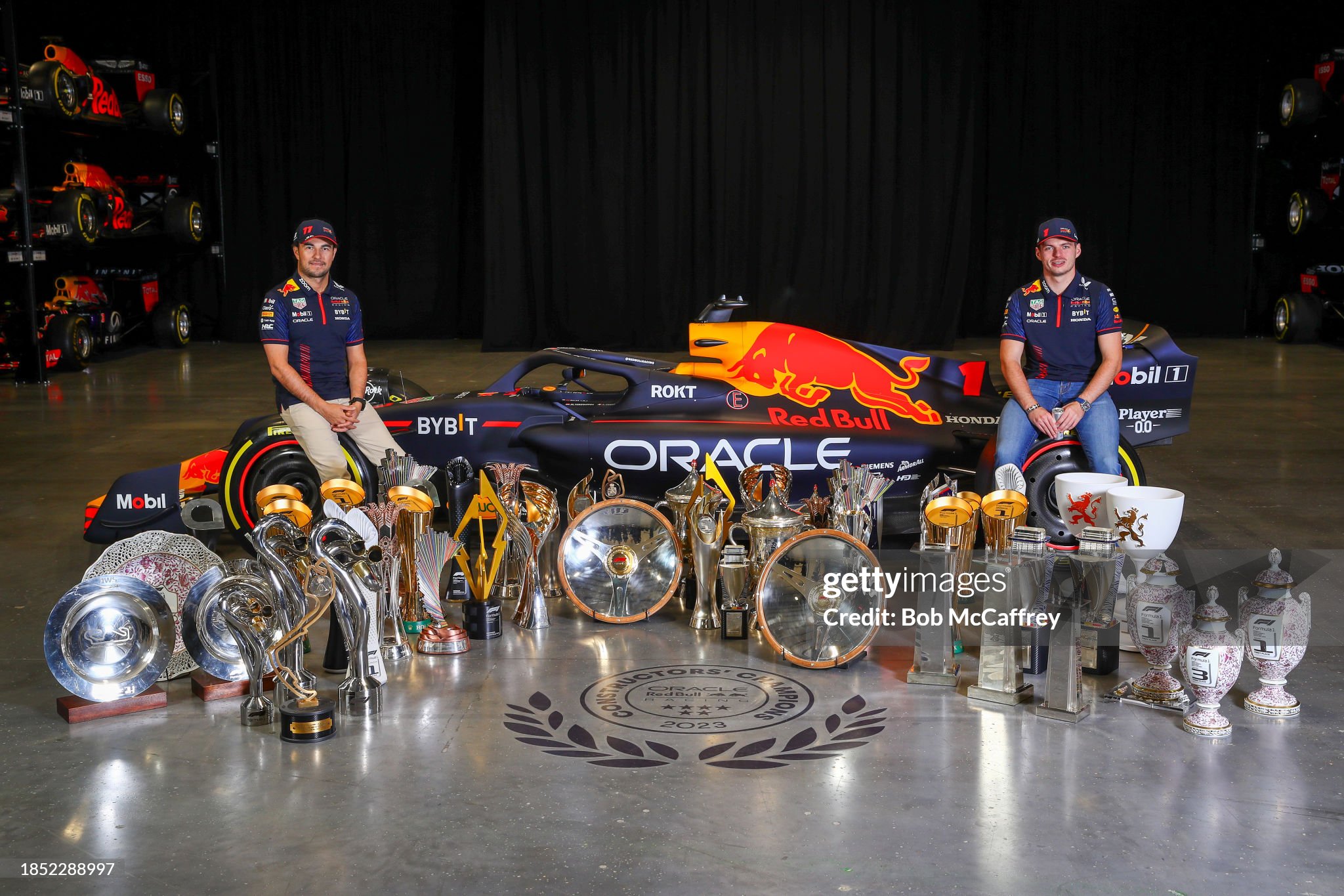 Sergio Perez and Max Verstappen pose for a photo with trophies during Max & Checo's Homecoming at Red Bull Racing factory on 13 December 2023 in Milton Keynes, England. 