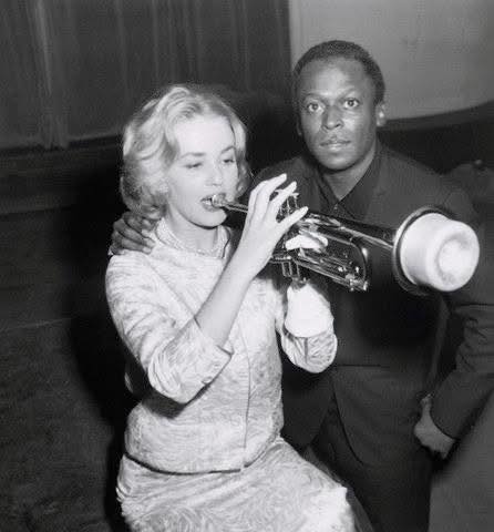 US trumpet player Miles Davis gives a lesson to French actress and singer Jeanne Moreau in Paris on 05 December 1957.
