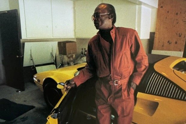 Miles Davis with his yellow 1980 Ferrari 308 GTSi.