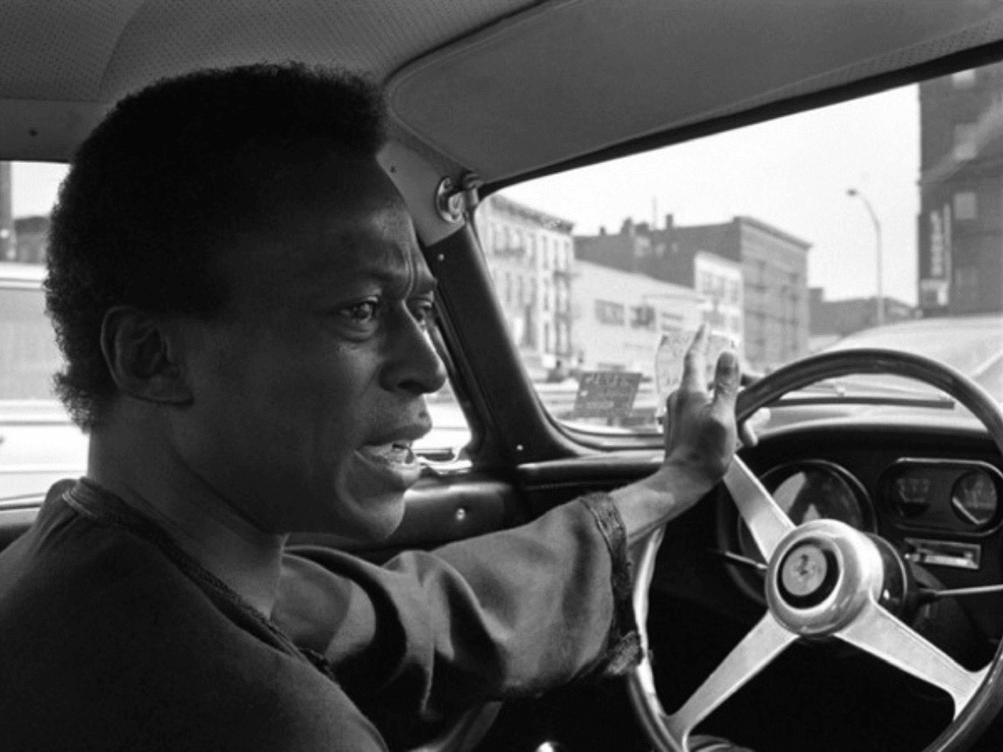 Miles Davis driving a Ferrari.