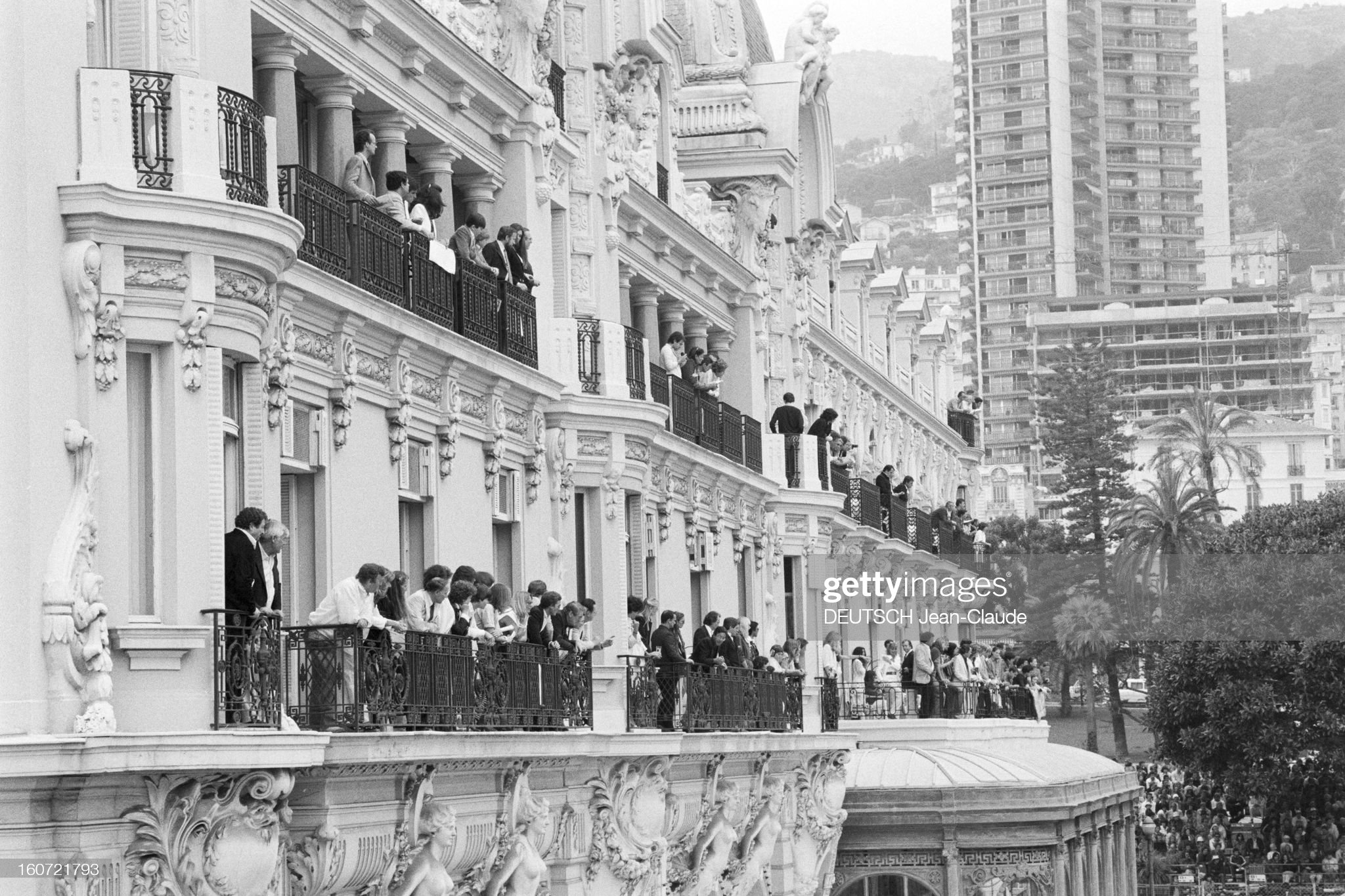 On May 18, 1980, during the Monaco Formula 1 Grand Prix, men and women on the balcony of a hotel watching the race.