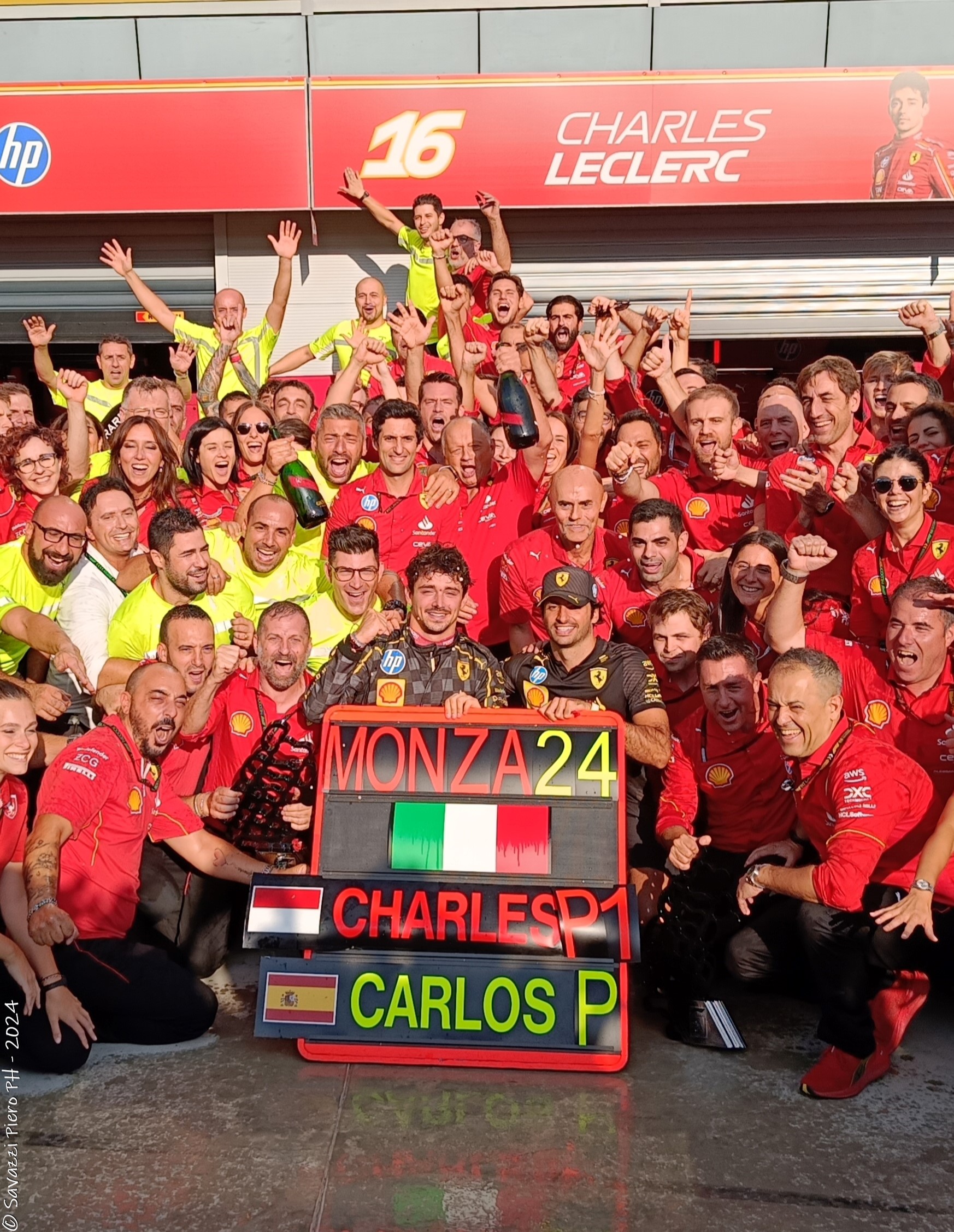 Group photo of the Ferrari team celebrating Charles Leclerc's victory. 