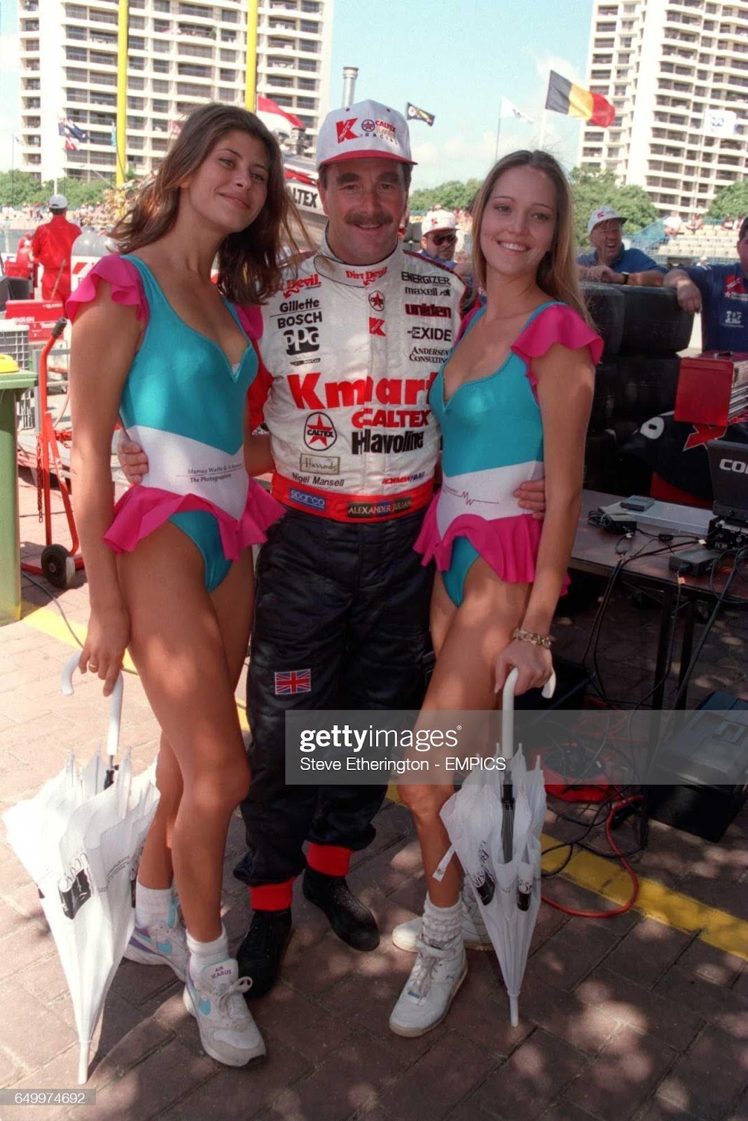 Nigel Mansell poses with promotion girls at Australian Indy car racing in 1994.