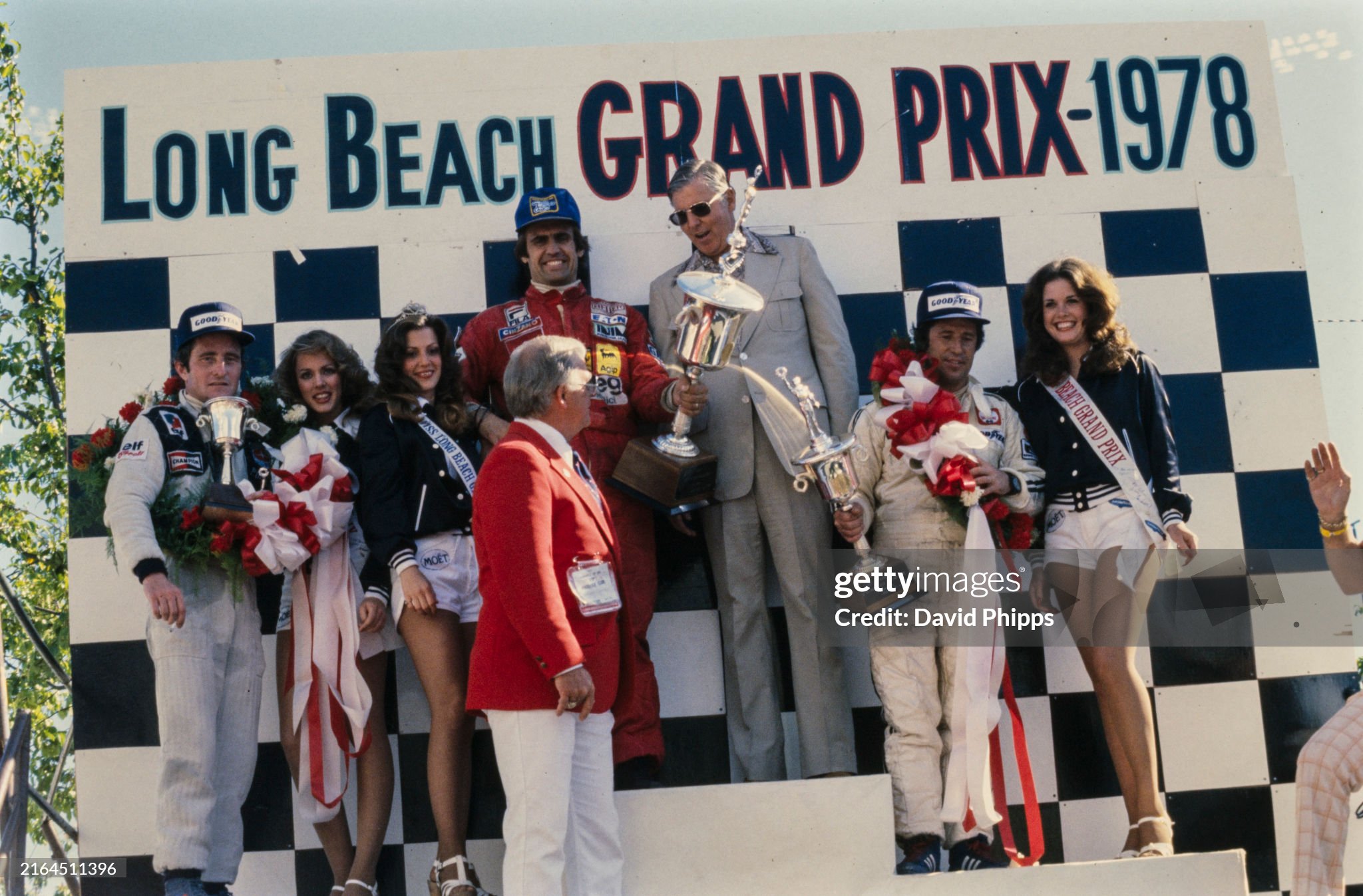 Carlos Reutemann celebrates victory on the podium with Mario Andretti, 2nd position and Patrick Depailler, 3rd position, at Long Beach on 02 April 1978. 