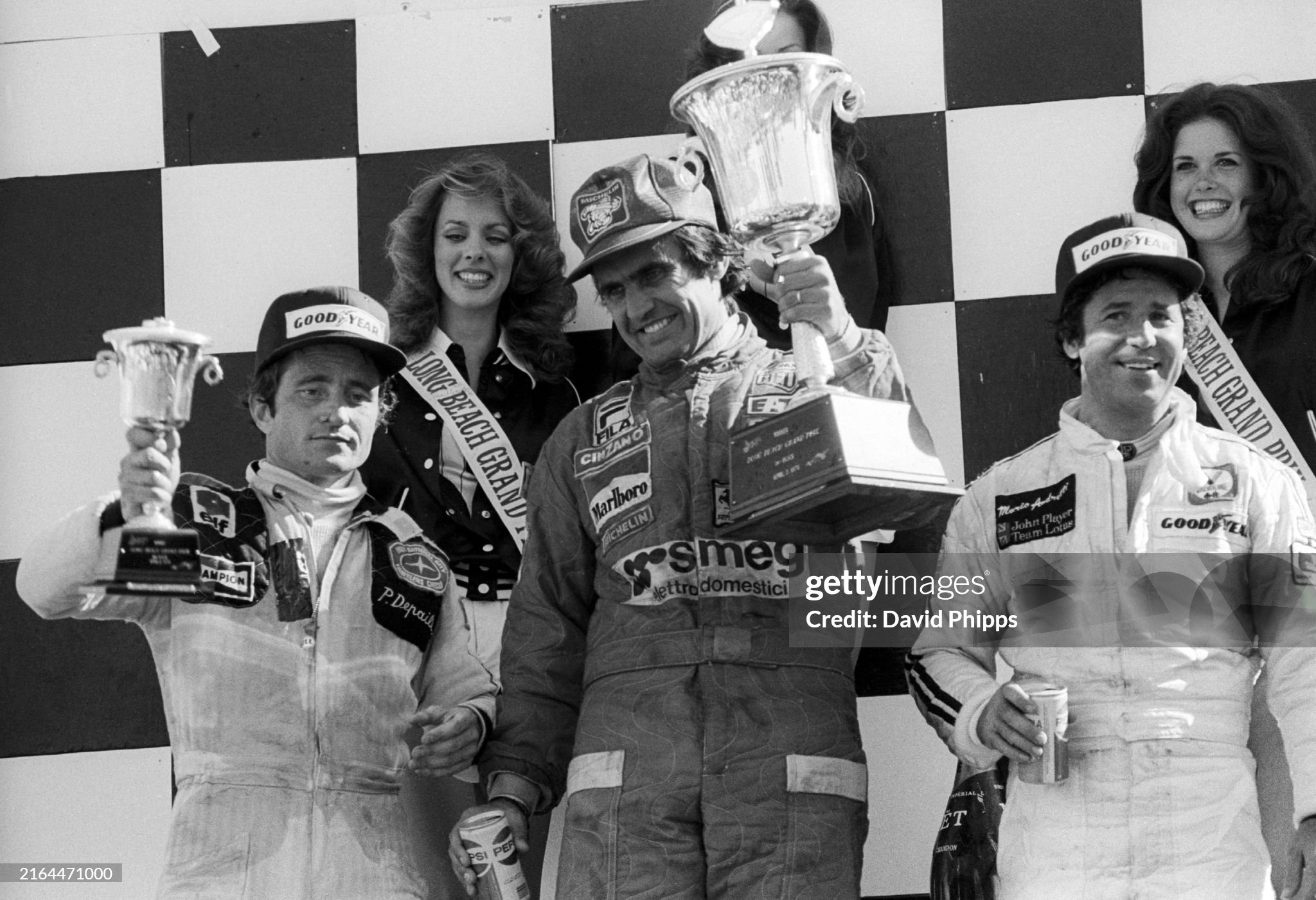 Carlos Reutemann celebrates victory on the podium with Mario Andretti, 2nd position and Patrick Depailler, 3rd position, at Long Beach on 02 April 1978. 