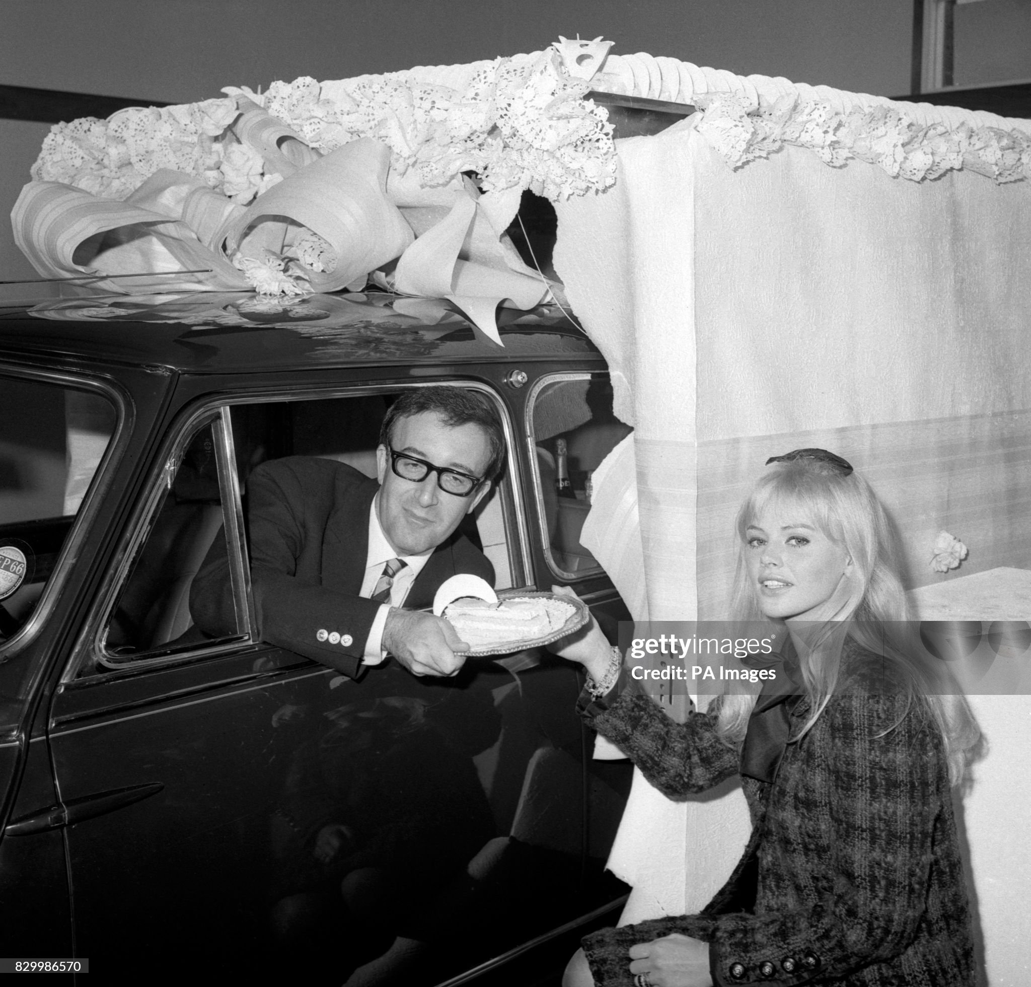 Actor Peter Sellers with his wife Britt Ekland after he had driven a Circassian blue Mini - a birthday present to his wife - through a gigantic cake after officially opening the new showroom for Harold Radford (Coachbuilders) Ltd at Hammersmith, London.