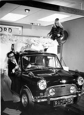 Peter Sellers drives a brand new ‘Mini’ car through a fake cake as his wife Britt Ekland ‘cuts the cake’.