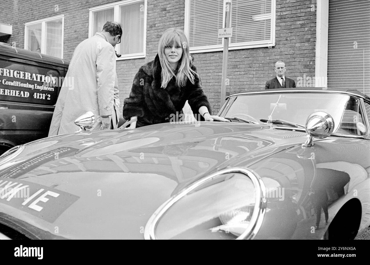 British comedian and actor Peter Sellers presents a gift of a red Jaguar E-Type car to his girlfriend Britt Ekland at Heathrow airport in London on 13th March 1967.