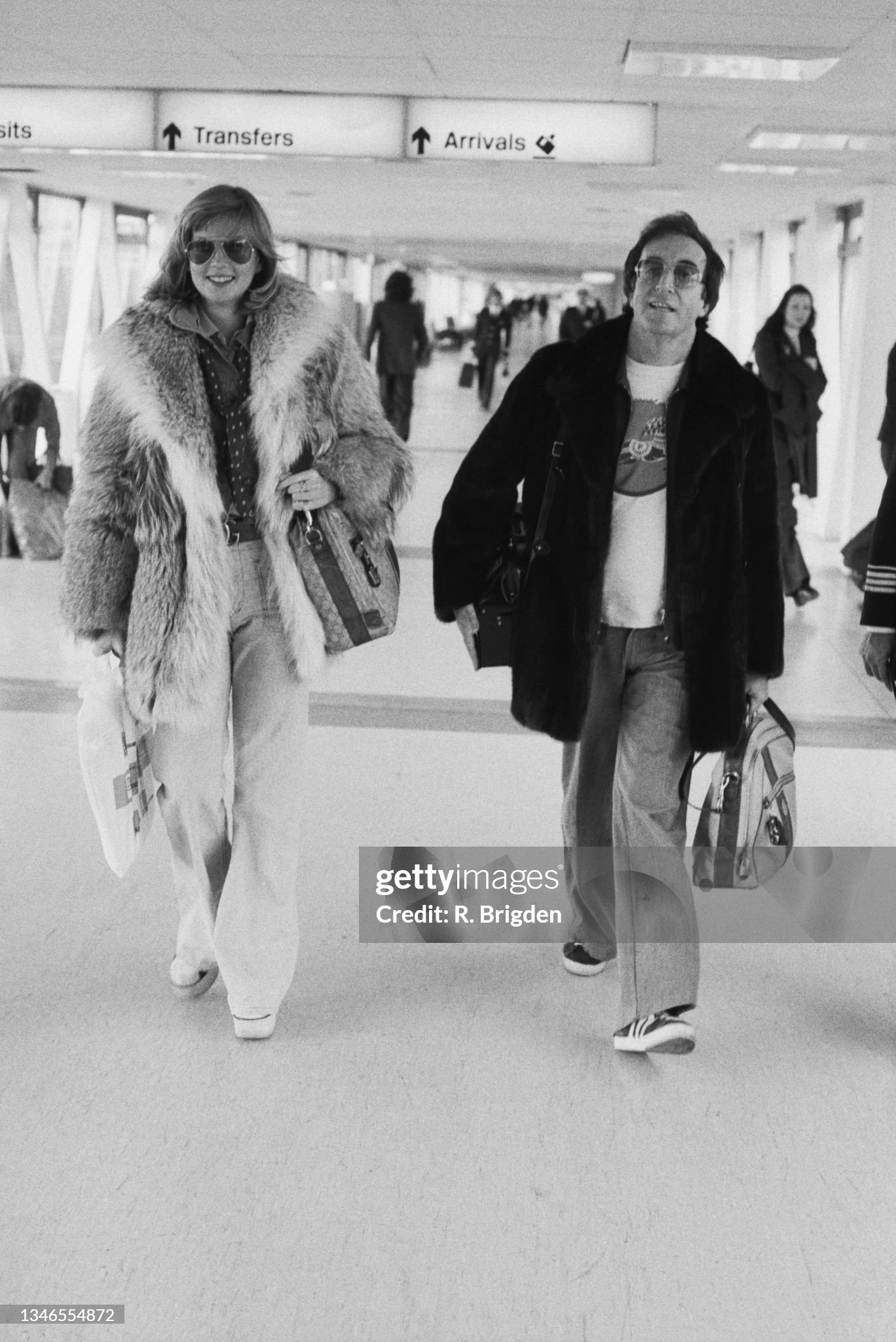 Peter Sellers with his girlfriend, Swedish model Christina 'Titi' Wachtmeister, at London's Heathrow Airport, UK, on 23 November 1974.