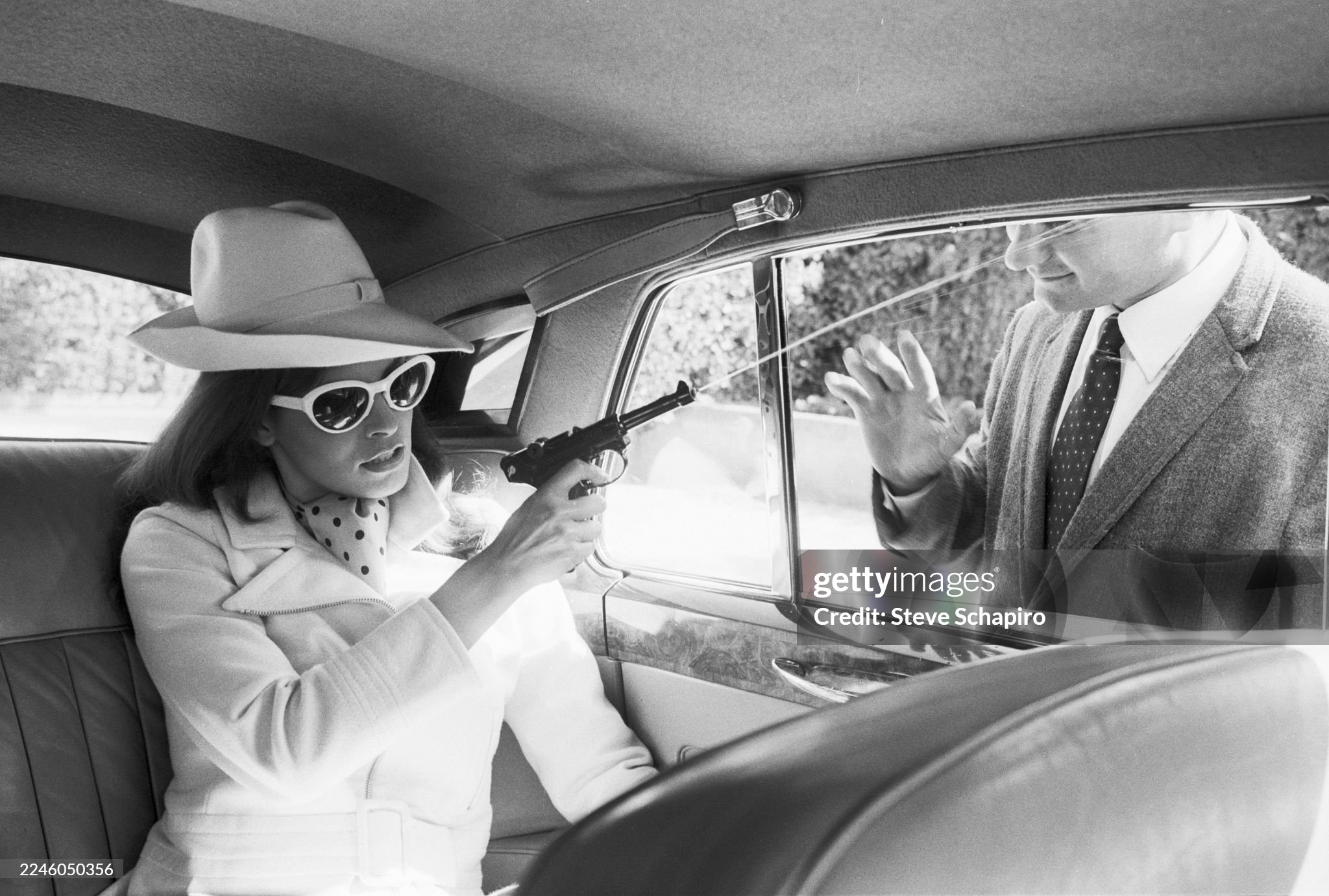 In the back seat of a car, American actor and model Raquel Welch aims a squirt gun and sprays a man outside the car window in Rome, Italy, in July 1966. 