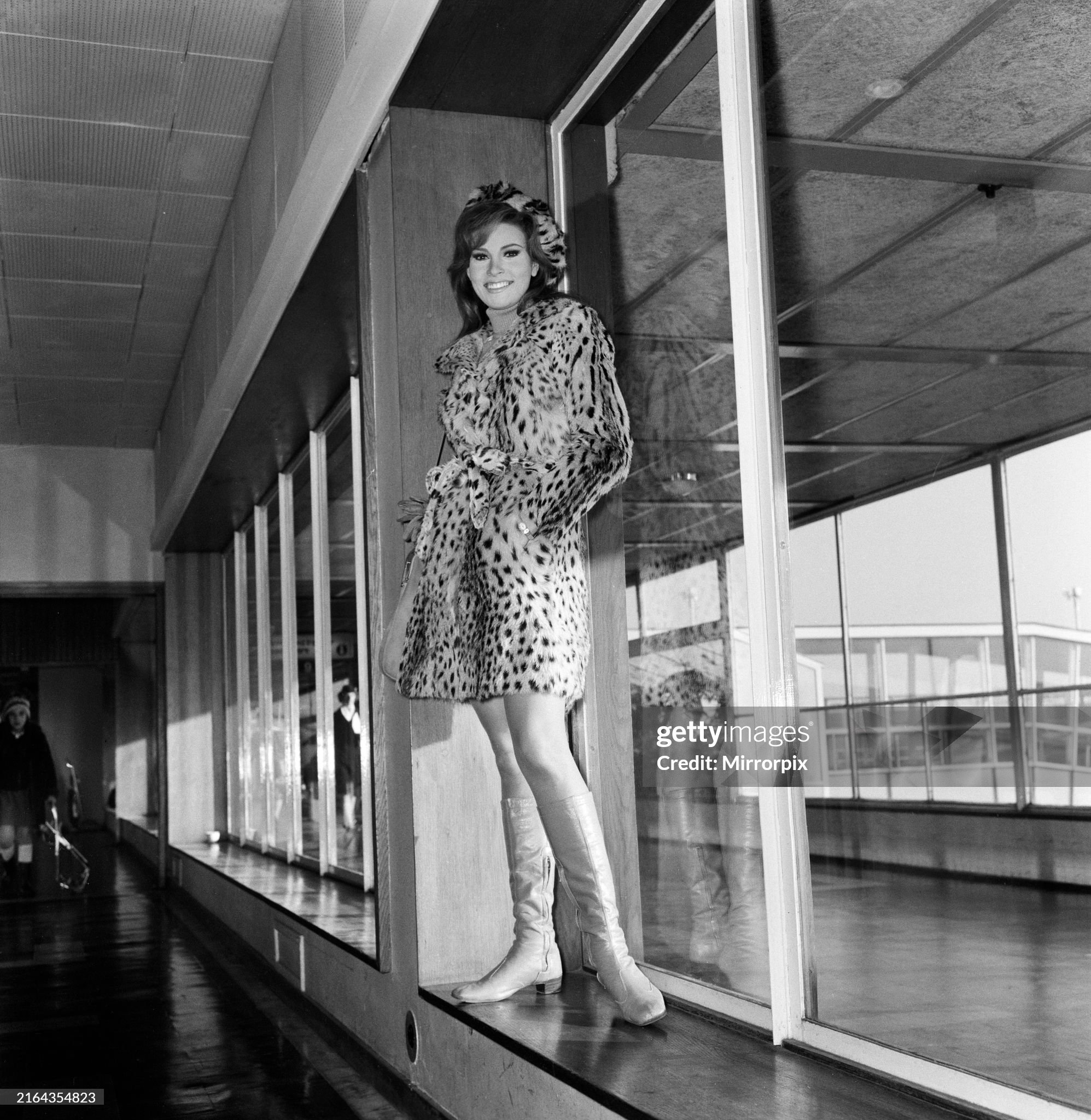 Raquel Welch leaving London airport for Berlin wearing her baby leopard skin coat over a mini skirt on 03 January 1967.