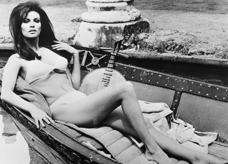 Portrait of actress Raquel Welch lying in a boat wearing a bathing suit on the set of 'The biggest bundle of them all' in 1968. 