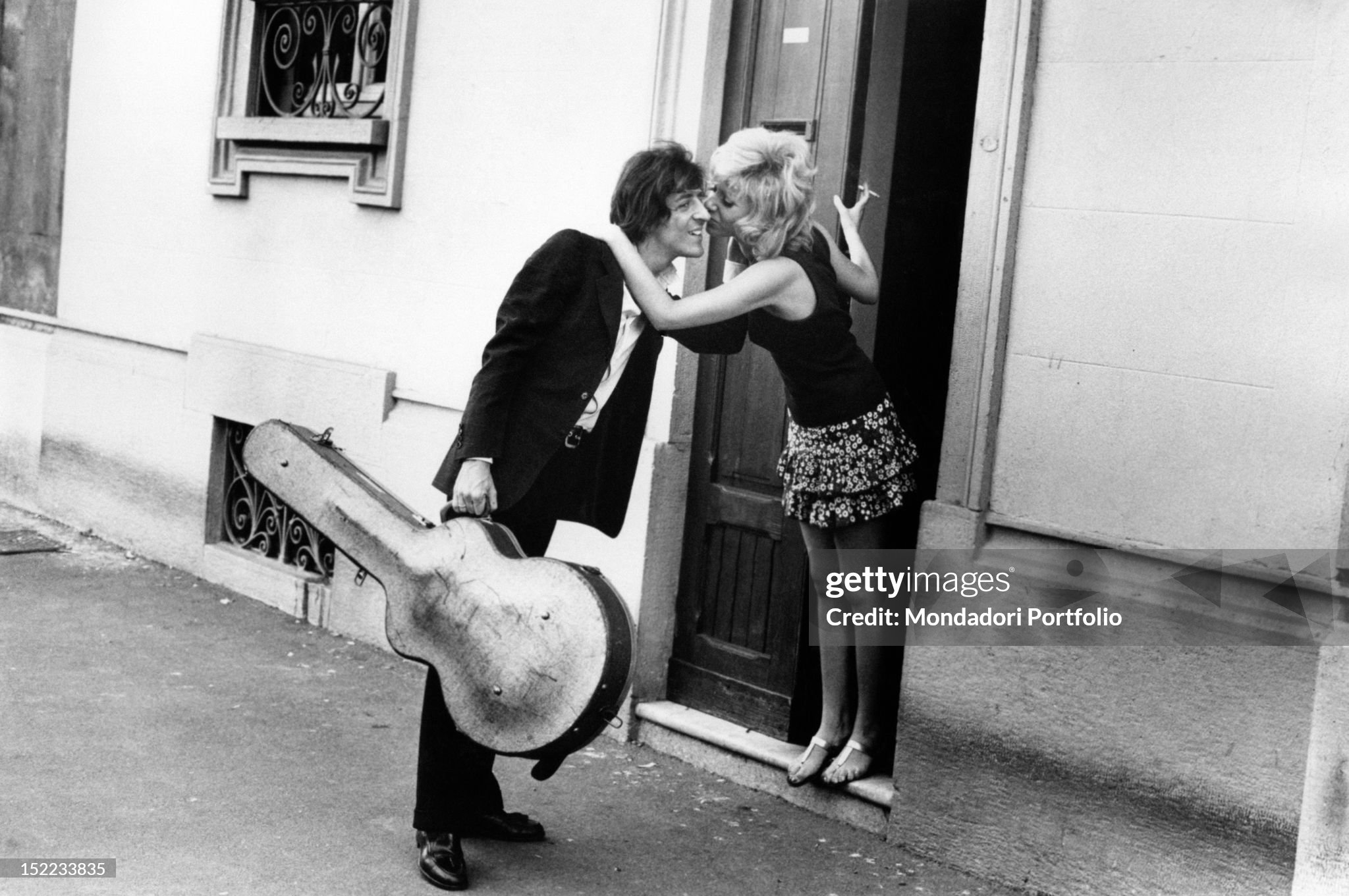 Italian songwriter, singer, actor and guitarist Giorgio Gaber (Giorgio Gaberscik) kissed by his wife, the Italian actress Ombretta Colli (Ombretta Comelli), on their doorstep in Milan in 1970s. 