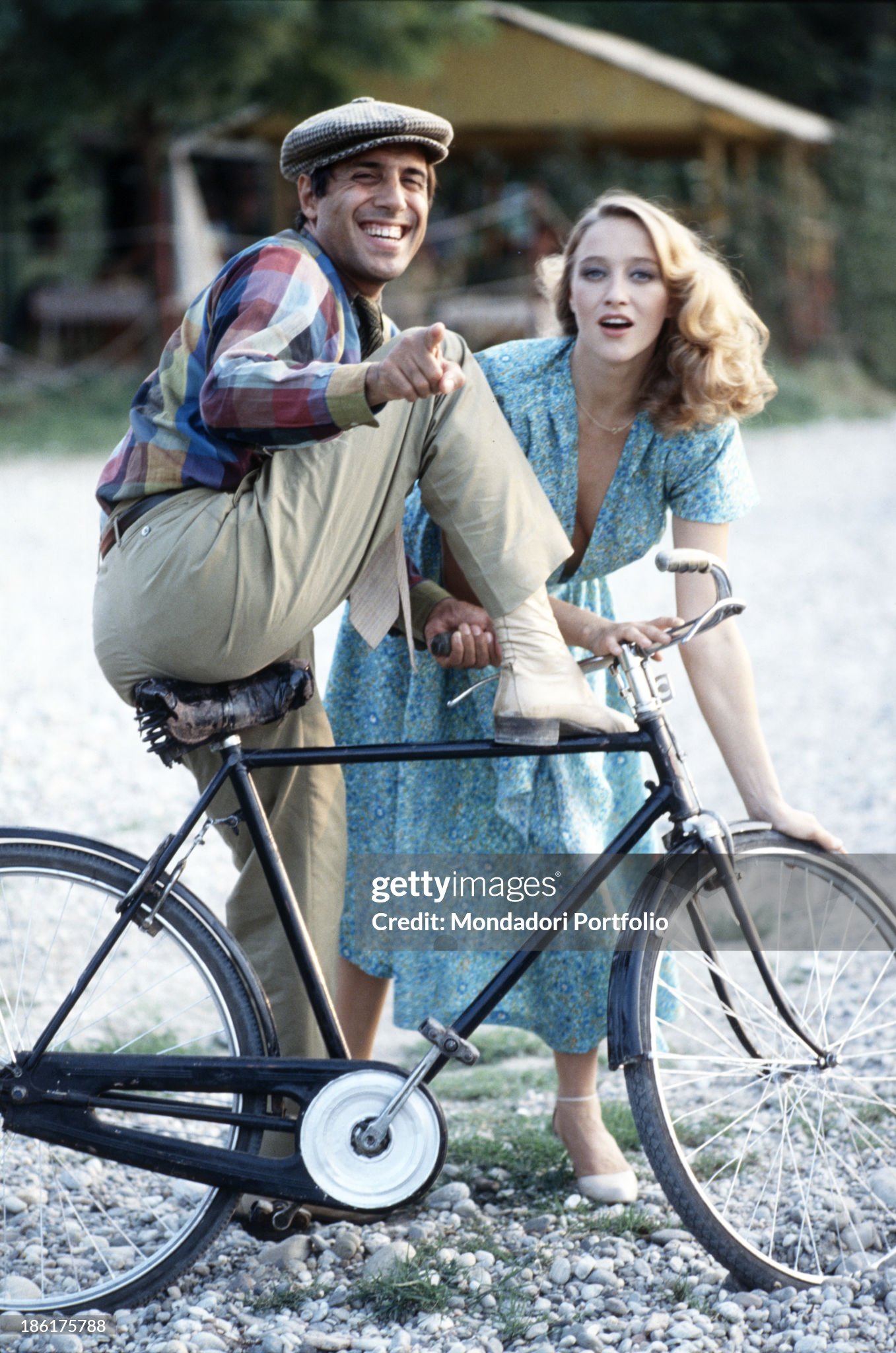 Adriano Celentano getting off a bicycle and laughing while Italian actress Eleonora Giorgi looking into the camera on the set of the film Velvet hands in Milan in 1979. 