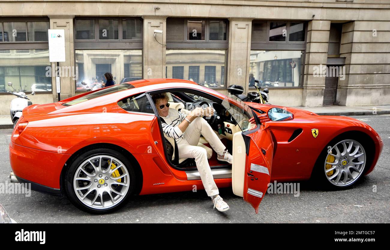 Sixty-six year old rocker Rod Stewart looks to be struggling as he gets out of his red Ferrari while out with a friend in London, UK, on 06 September 2011.
