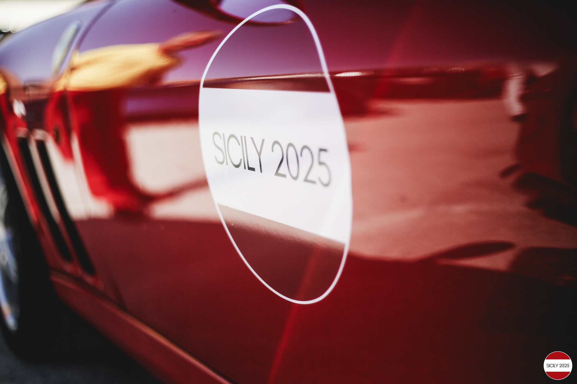 The side of a Ferrari with the event logo.