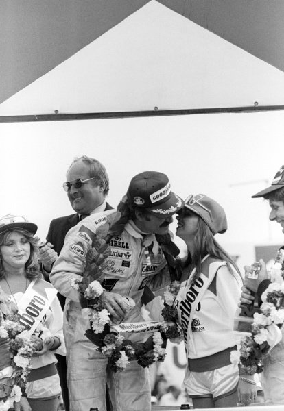 Race winner Clay Regazzoni, Williams, kisses one of the Marlboro grid girls on the podium at the British Grand Prix in Silverstone, England, on 14 July 1979.