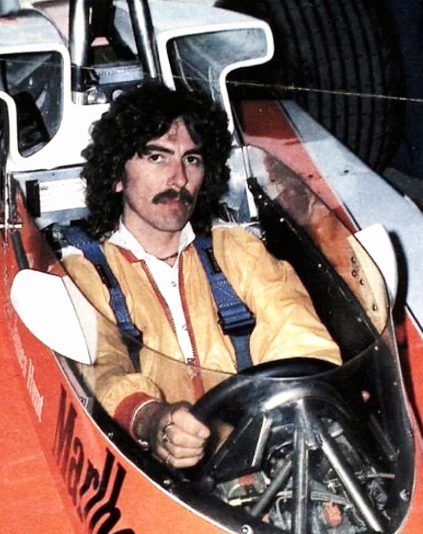 George Harrison sitting in the cockpit of James Hunt's McLaren M23 Formula 1 car.