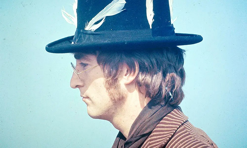 John Lennon, wearing a hat decorated with feathers, takes part in filming of the television musical film 'Magical mystery tour' on 14 September 1967. 