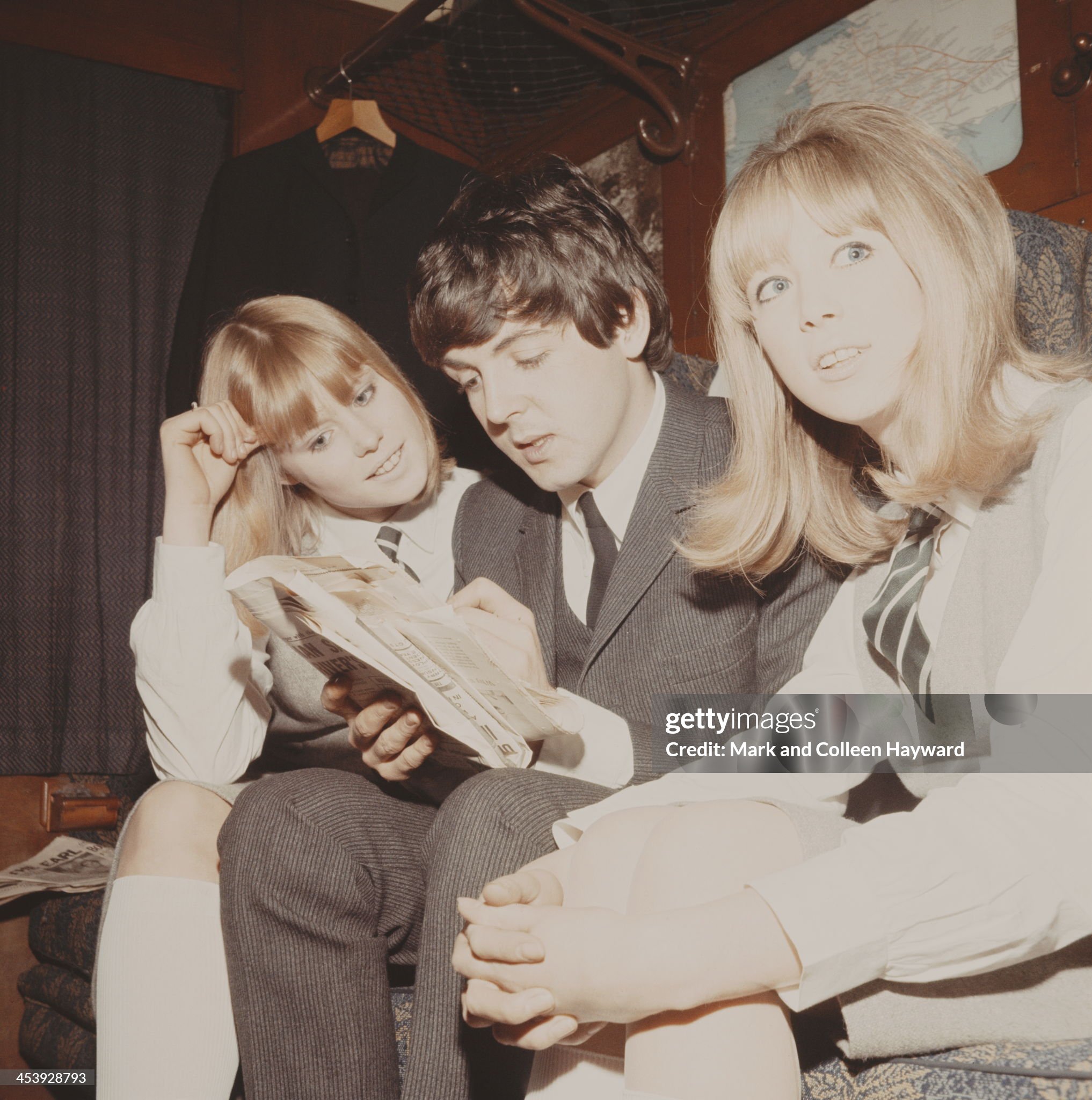 Paul McCartney completes a crossword puzzle with Patti Boyd (right) and another extra.