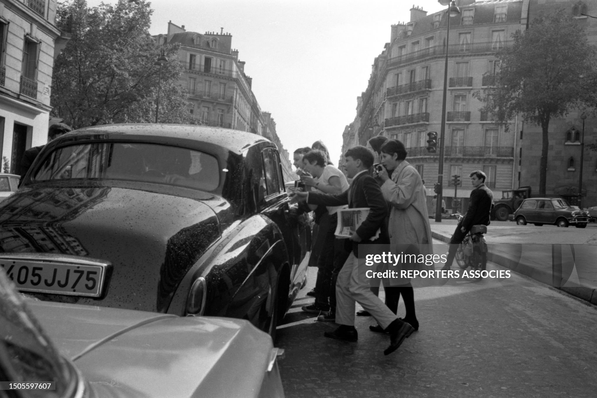 The Beatles' car mobbed by fans in the street in Paris on 20 June 1965. 