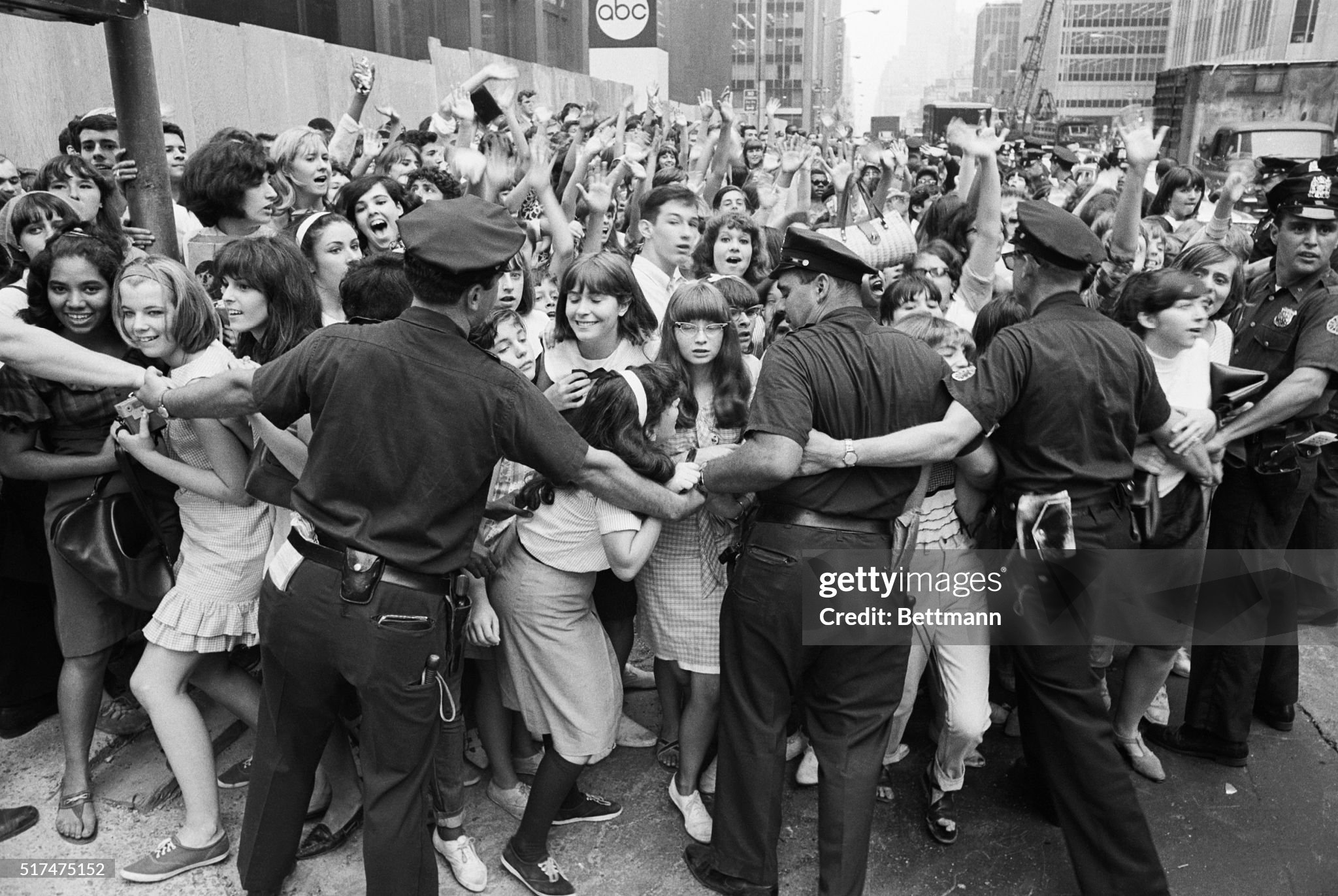 New York City policemen try to restrain hordes of teenagers, mostly of the female variety, from crashing into the Warwick Hotel, the Beatles' New York residence, on 12 August 1965. 