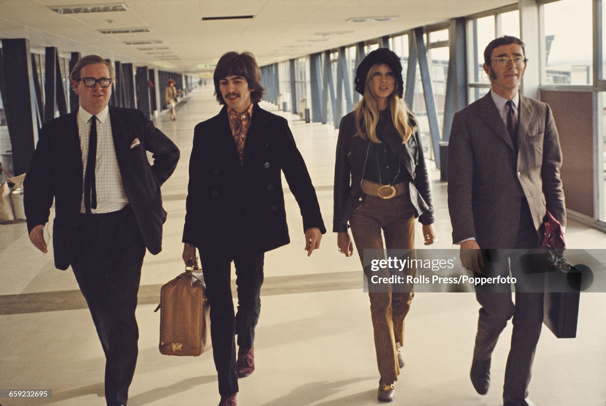 George Harrison pictured with his wife Pattie Boyd and two minders as they walk through a terminal at Heathrow Airport in London in 1970.