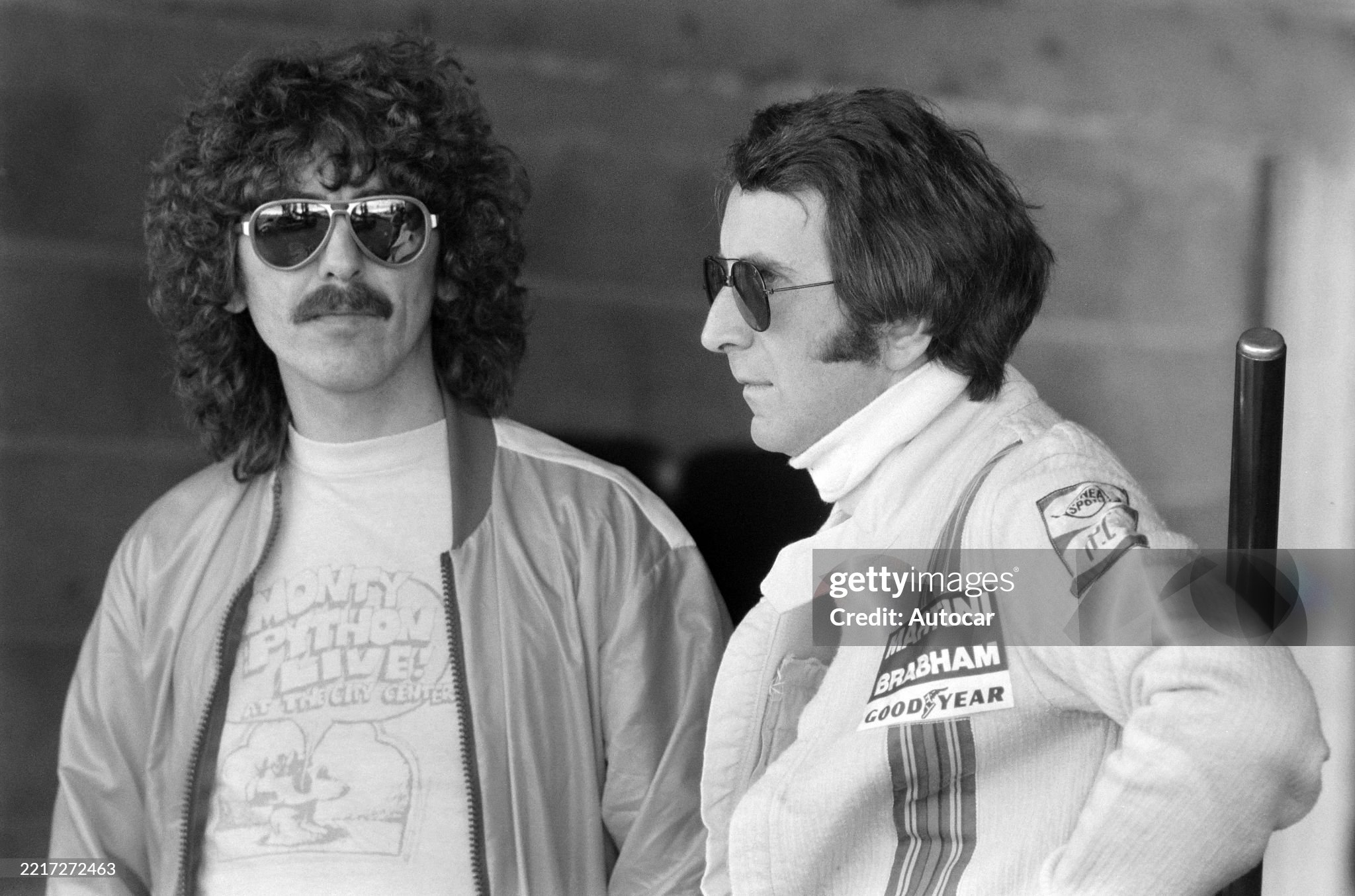 George Harrison with John Watson in the pit lane at the French Grand Prix in Dijon-Prenois, 1st - 3rd July 1977. 