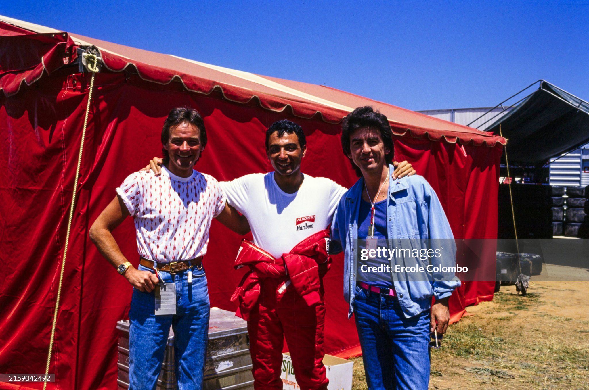 Michele Alboreto poses with Barry Sheene and George Harrison during the Australian Grand Prix at Adelaide Street Circuit on 03 November 1985. 