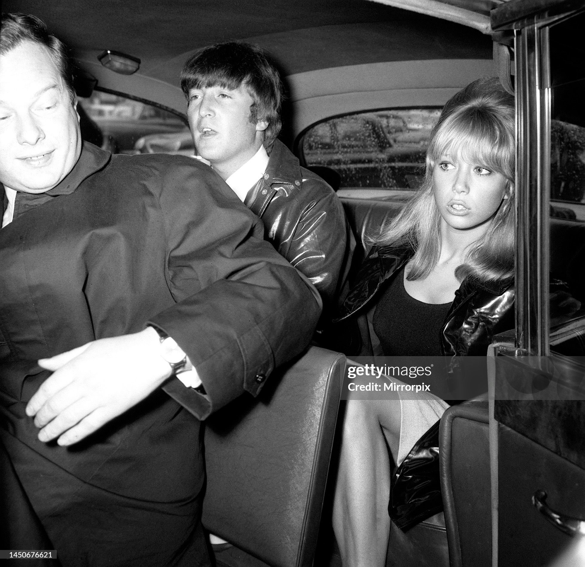 John Lennon with his wife Cynthia in the back of a car on 26th May 1964. 