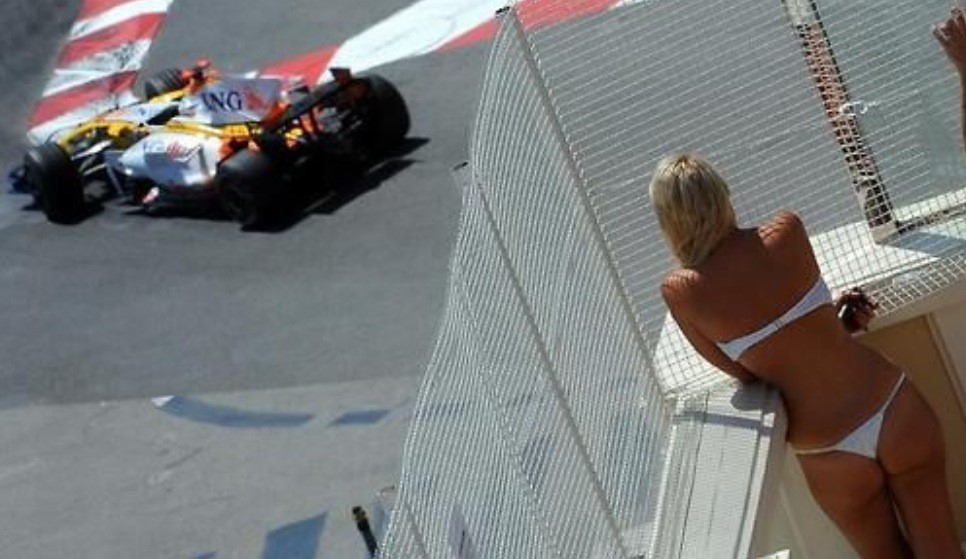 Fernando Alonso at Monaco wached by a girl in a bikini.