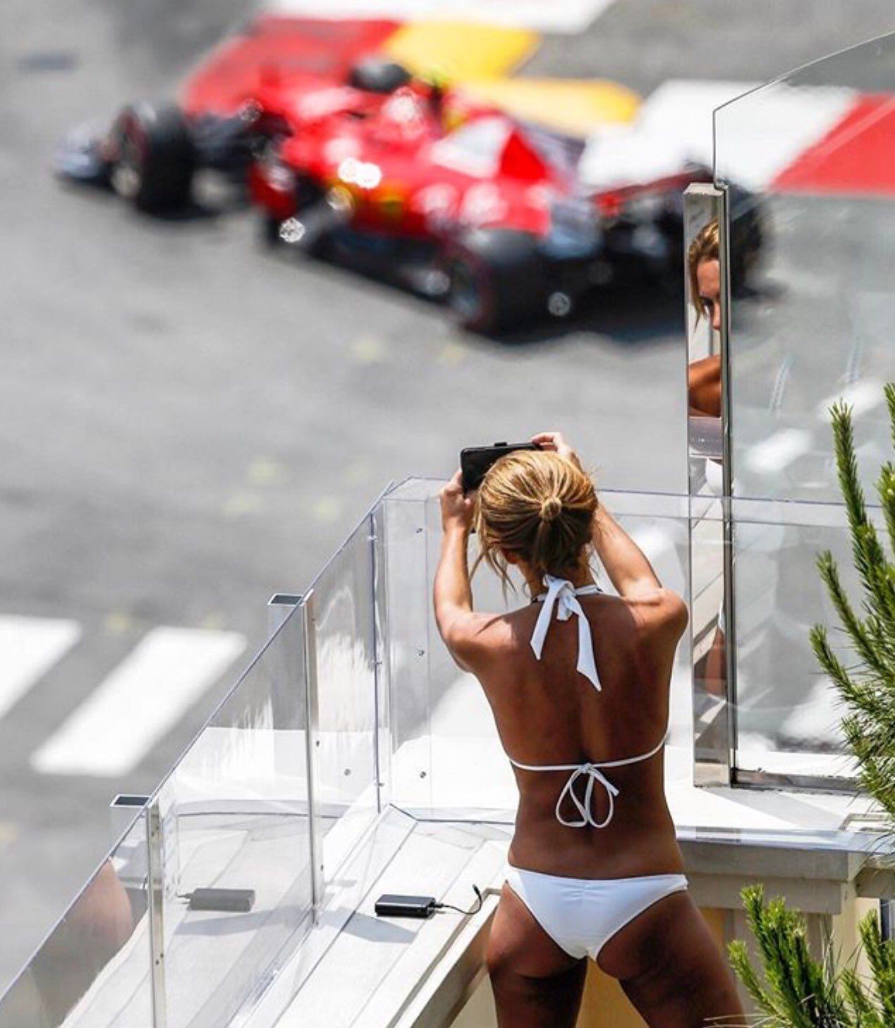 A Ferrari at Monaco watched by a girl in a bikini.
