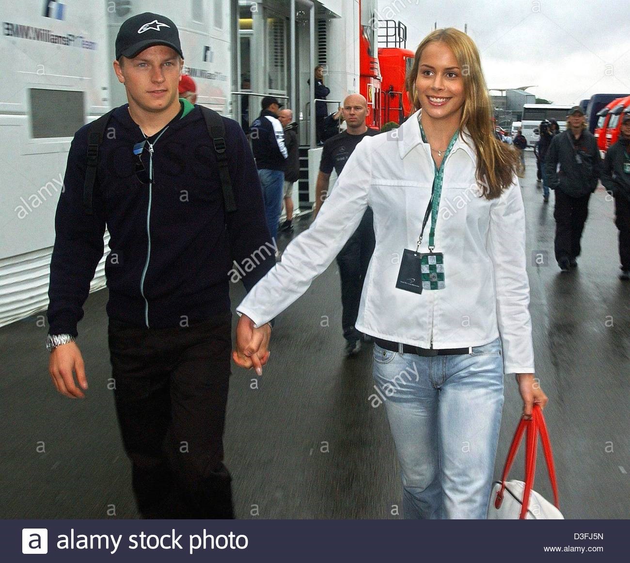 Finnish Formula 1 driver Kimi Raikkonen walks hand in hand with his girlfriend Jenny Dahlmann past the pit stops at the F1 racetrack in Silverstone, UK, 17 July 2003.