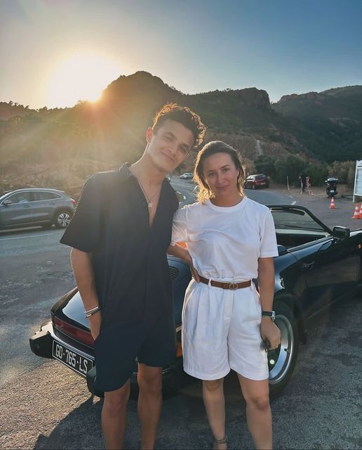 Lando Norris stops for a photo with a fan in front of his classic Porsche 911 convertible.