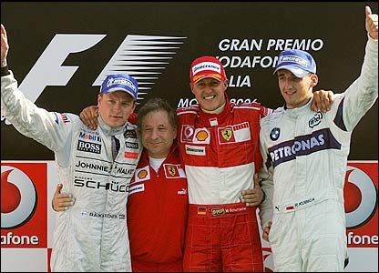 Ecstatic Ferrari fans cheer as Schumacher smiles alongside second-placed Raikkonen (left) and a delighted Kubica (right).