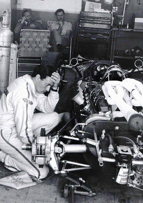 Jim Clark, Lotus-Ford 38, with Colin Chapman and Graham Hill looking on from the back of the pits.