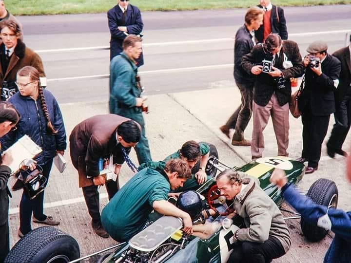Colin Chapman in a Lotus at the pits with Colin Chapman.