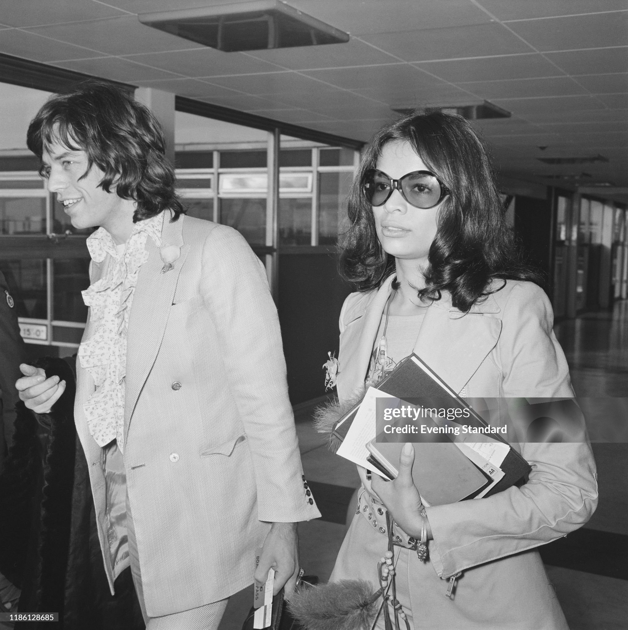 Mick Jagger and his girlfriend Bianca Perez-Mora Macias arrive at London's Heathrow Airport to catch a flight to the Bahamas for a holiday on 25 November 1970. 