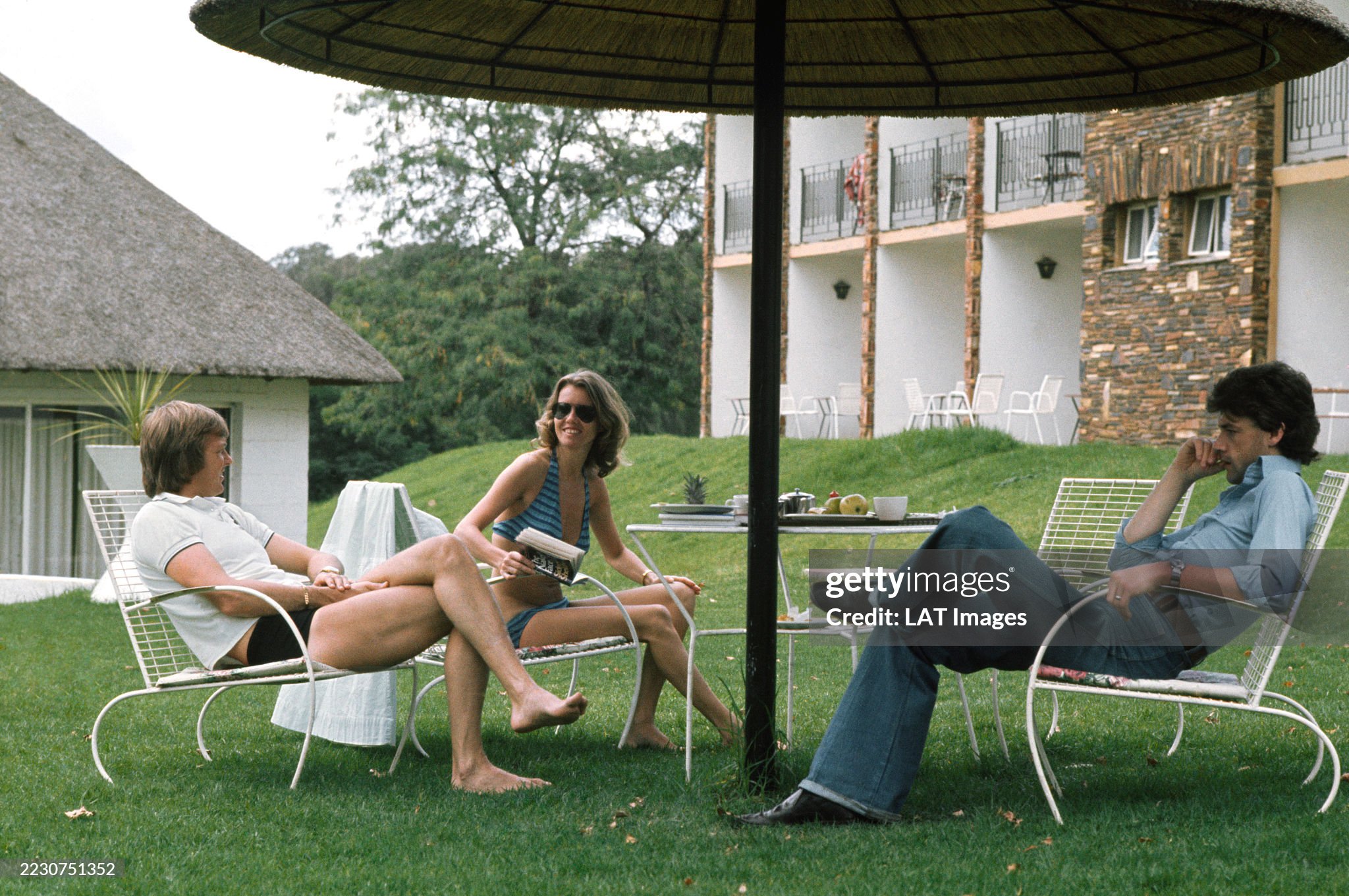 Ronnie Peterson, March 761-Ford, relaxes with his wife Barbro and Tom Pryce, Shadow DN5B-Ford, at Kyalami on 06 March 1976. 