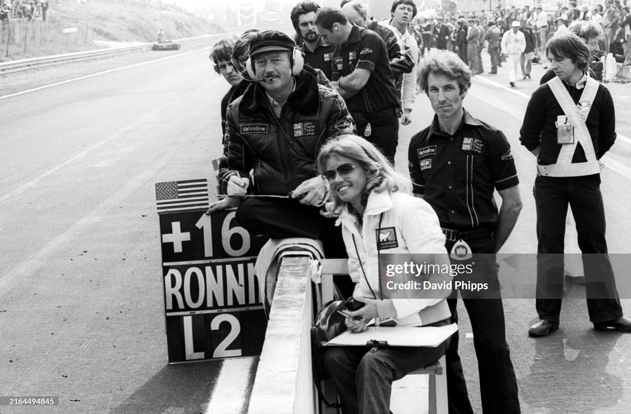 Colin Chapman, Lotus Team owner, watches the race from the pit wall in the closing stages with Barbo Peterson and Bob Dance, Lotus mechanic, anticipating a 1-2 finish for the team at the Belgian Grand Prix in Zolder on 21 May 1978. 