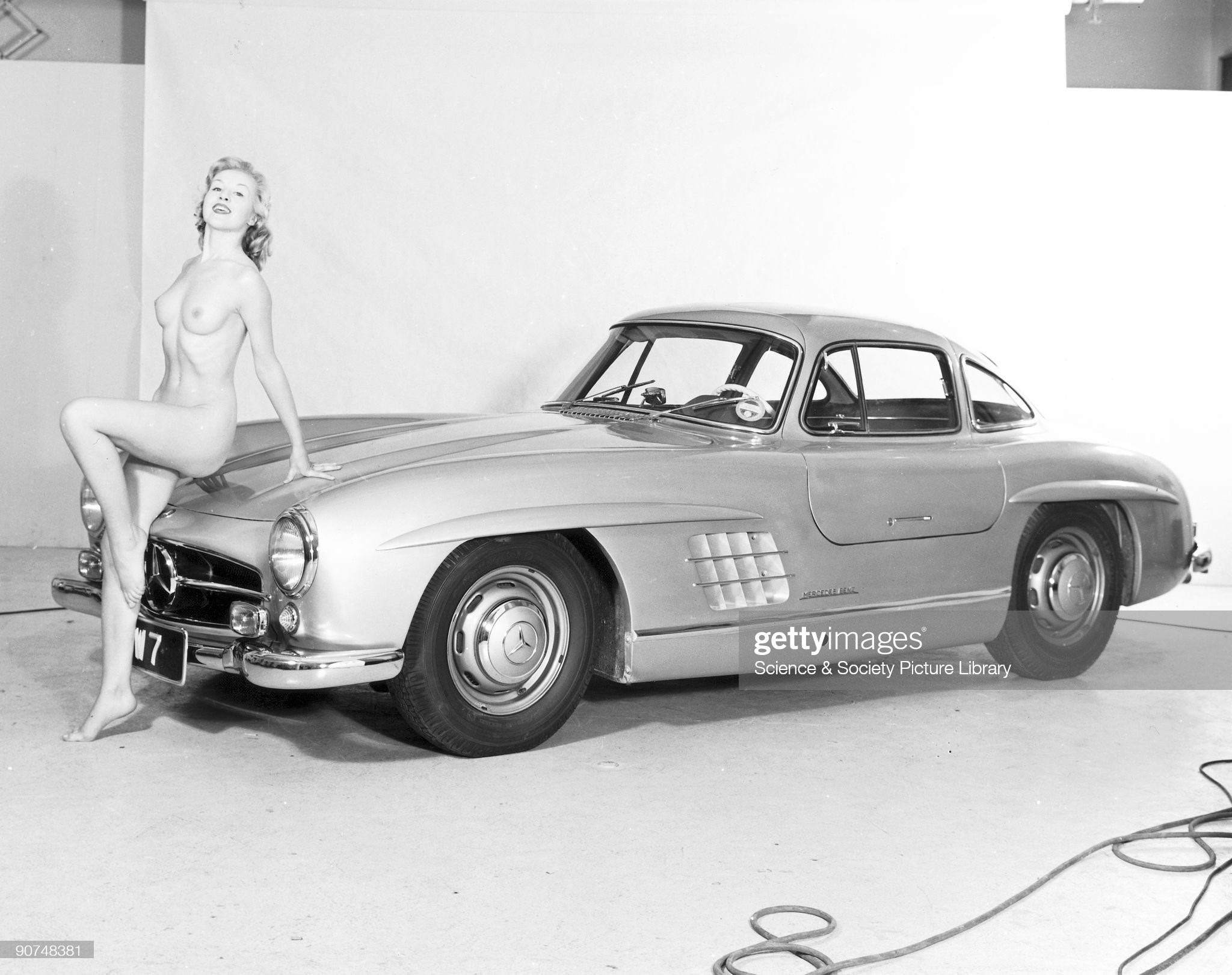 Nude model and Mercedes wing-door car, c 1961. Germany, July 13: model reclining on a Mercedes. 