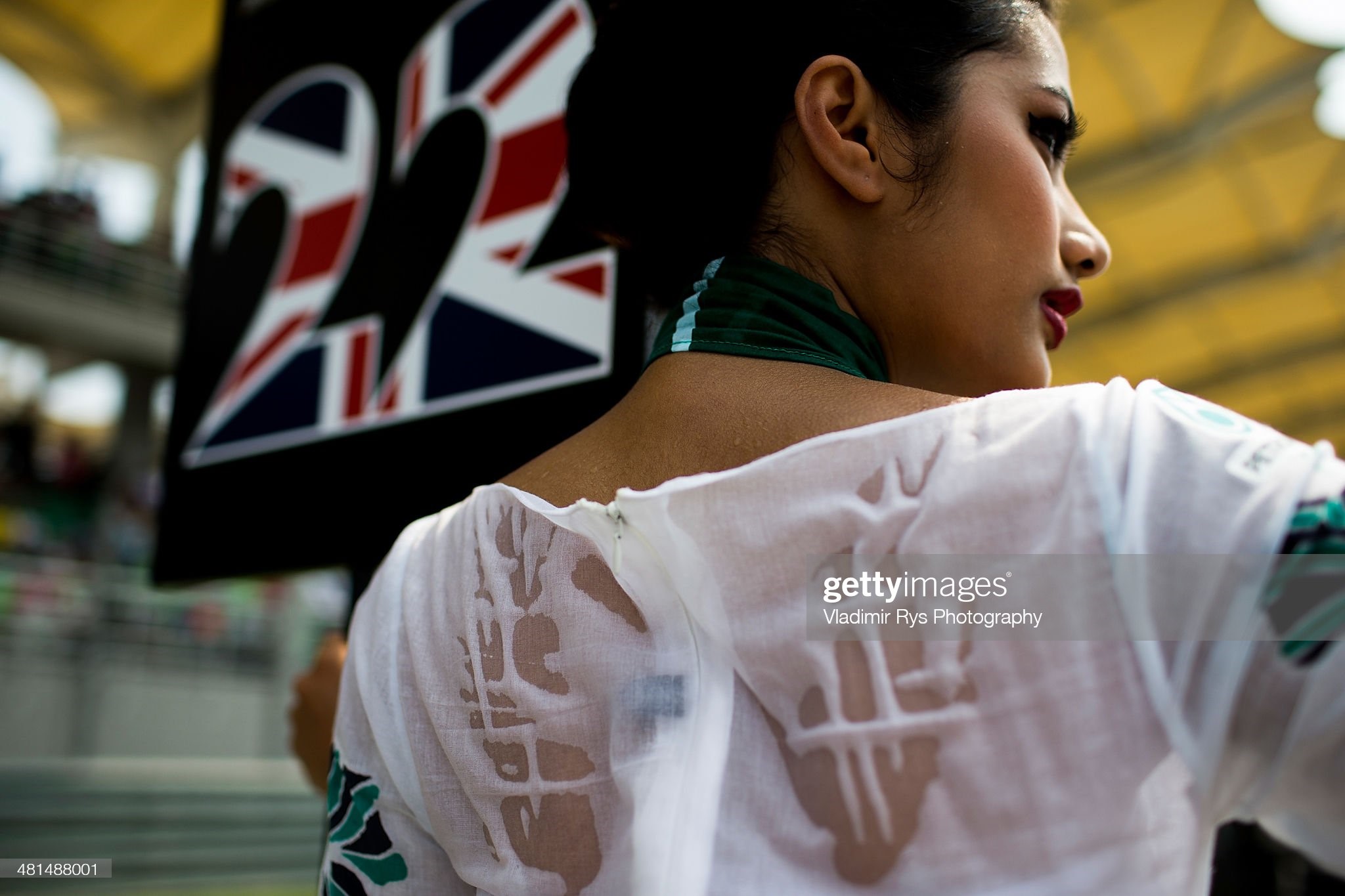 A grid girl stands in the heat on the starting grid ahead of the Malaysian Formula One Grand Prix at Sepang International Circuit on March 30, 2014 in Kuala Lumpur, Malaysia. 