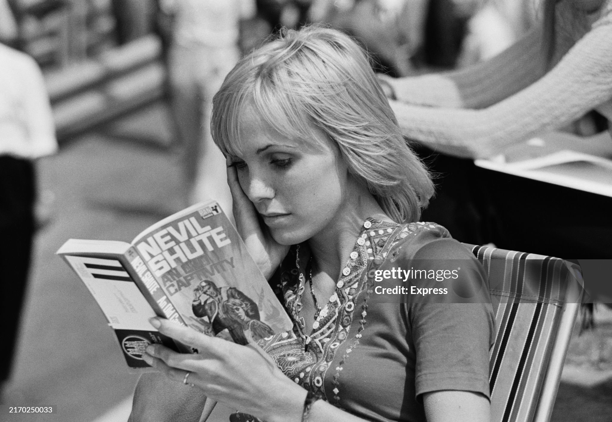 Sally Courage reading a novel during the Formula 1 Dutch Grand Prix in Zandvoort, Holland, on 21 June 1970. Courage's husband, racing driver Piers Courage, died later that day in a crash. 