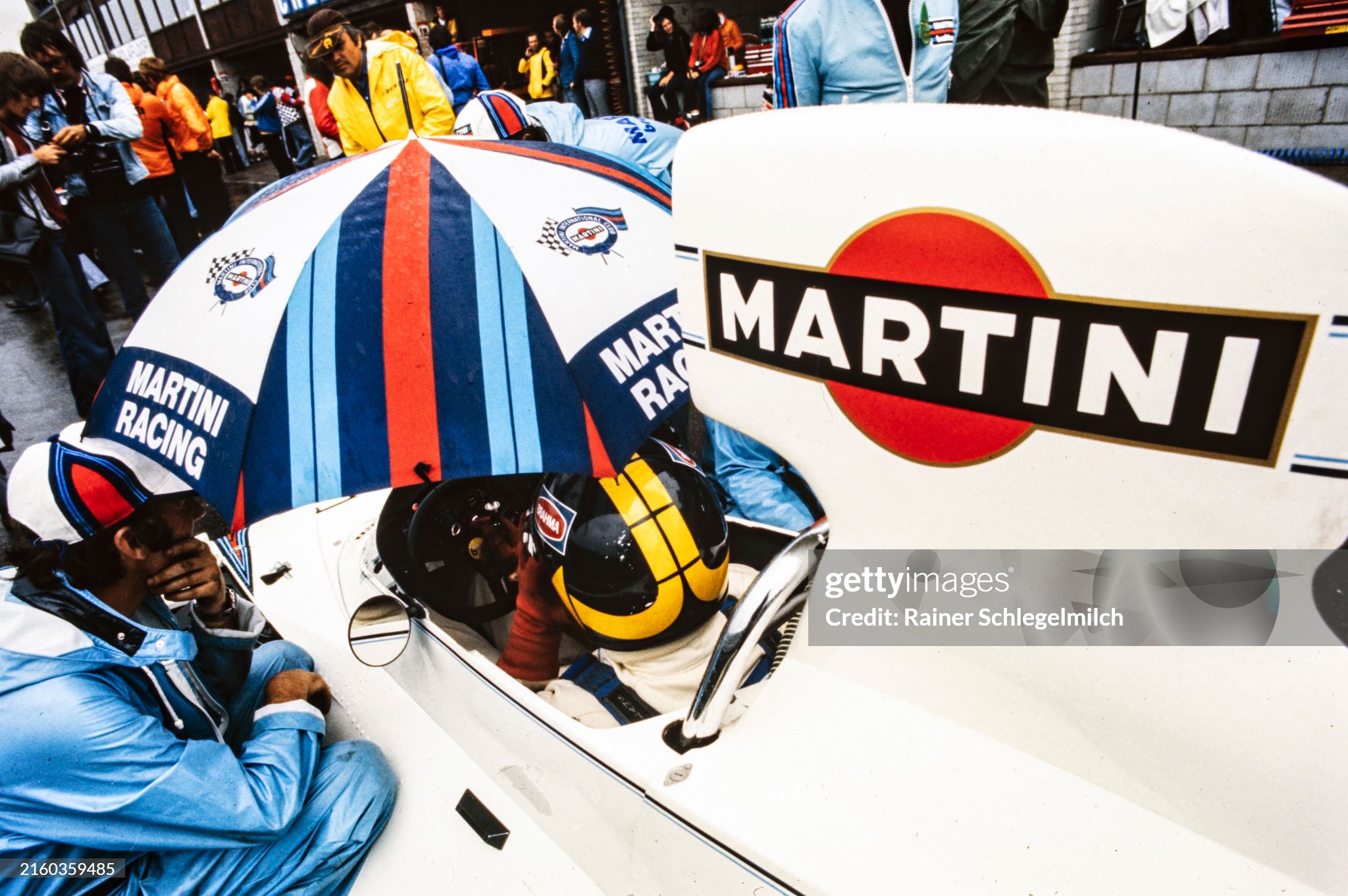 Carlos Pace sheltering under an umbrella while speaking to a team member at the Dutch Grand Prix in Zandvoort, Holland, on 22 June 1975. 