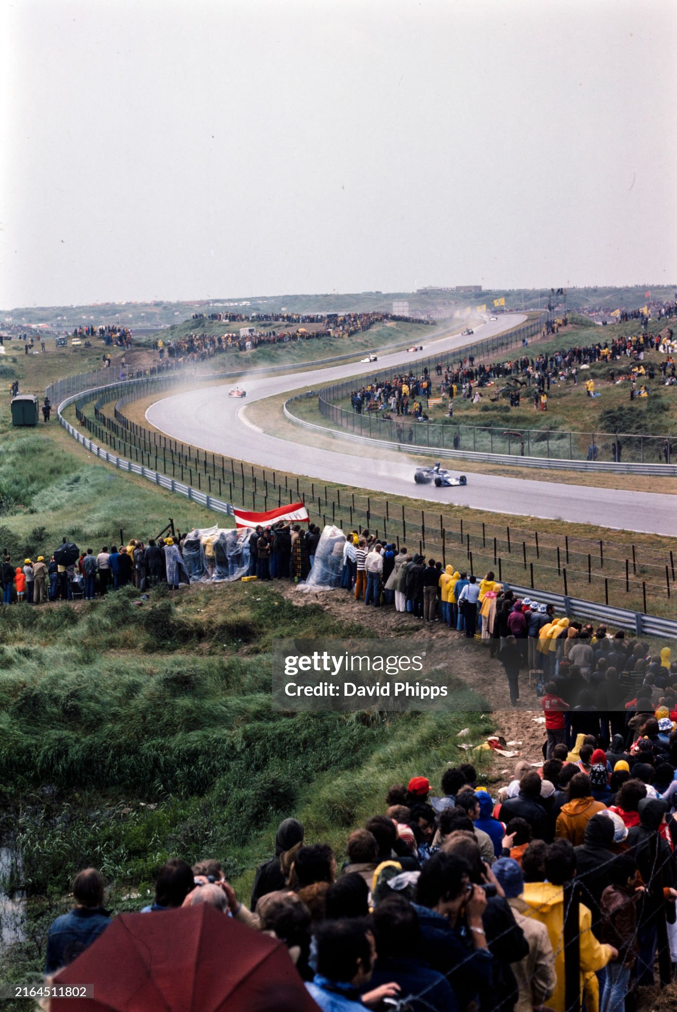 Crowds watch as Jody Scheckter’s Tyrrell 007 Ford passes by a bank of fans during the Dutch Grand Prix in Zandvoort, Holland, on 22 June 1975. 
