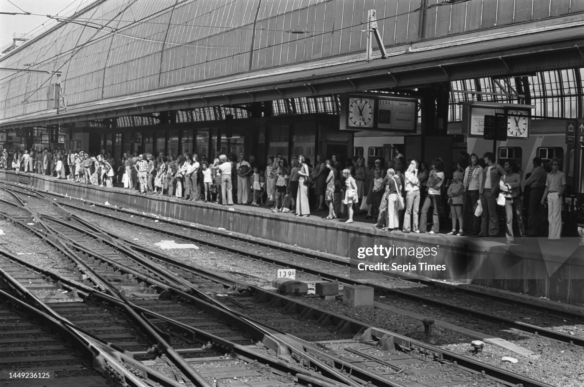 Queue of people waiting on a platform of Central Station for the train to Zandvoort on 04 August 1975.